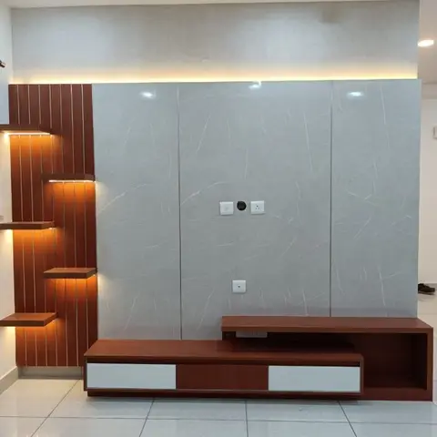 Empty room with a grey marble-look TV feature wall bordered by wood fluted panelling and backlit floating display ledges