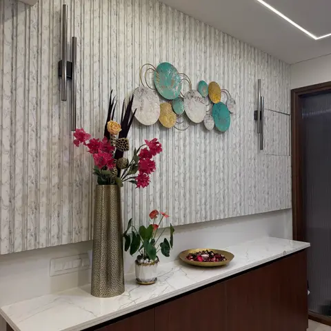 Entrance console styled with a marble-top wood cabinet, brass vases with dried flowers