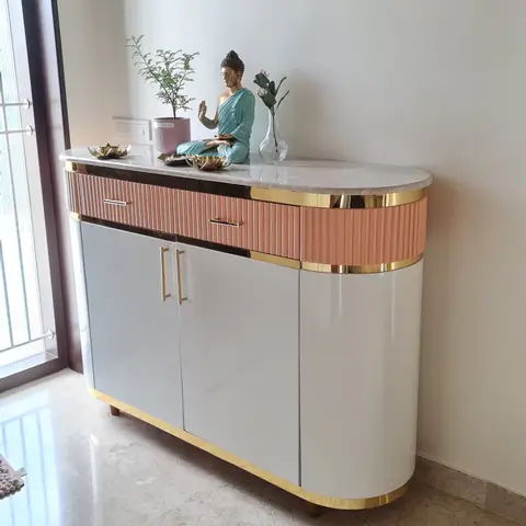 Entrance console with a curved pink-fluted and grey lacquer cabinet, brass trim, and a marble top styled with a Buddha statue and potted plant.
