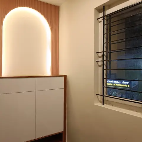 Entrance foyer with a backlit arched niche in fluted terracotta panelling above a white gloss storage console