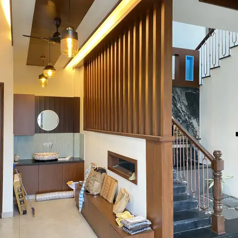 Entrance foyer with a backlit fluted-wood partition dividing the hallway from a marble-clad staircase, a built-in bench below it