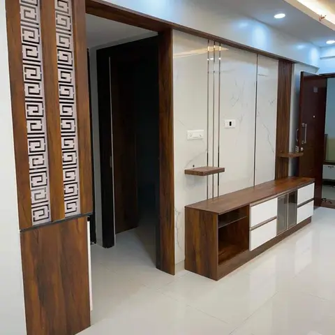 Entrance foyer with a carved wood geometric jaali screen beside a marble feature wall and a wall-mounted wood and white TV console