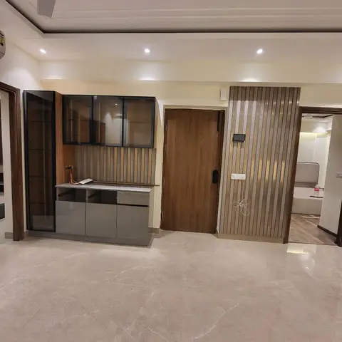 Entrance foyer with a fluted-panel main door surround, a glass-front display unit, and marble flooring, still with exposed wiring near the entry panel