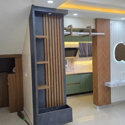 Entrance foyer with a fluted wood-and-stone partition screen, under-stair wood storage cabinets, and a backlit organic-shaped mirror above a marble console