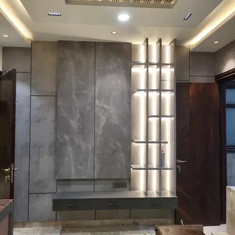 Entrance foyer with a grey stone-clad feature wall, a backlit ladder-shelf display niche, and a floating console beneath