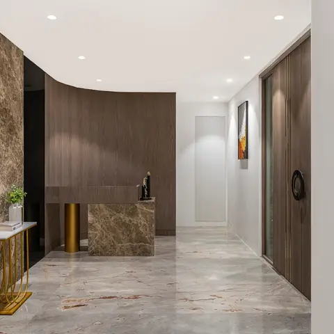 Entrance foyer with a marble-clad feature wall, a curved wood console unit, and a brass-legged side table on veined marble flooring.