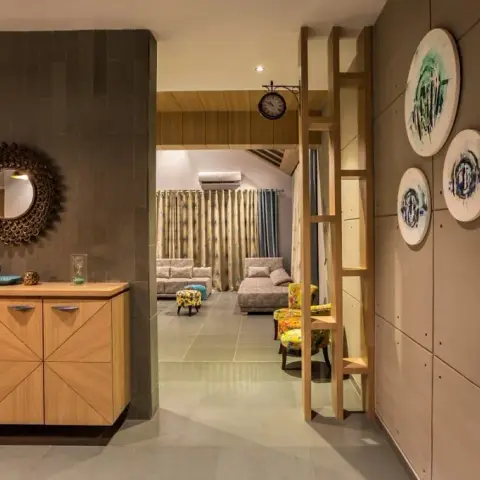 Entrance foyer with a sunburst mirror over a herringbone-front wood console, next to a textured concrete wall styled with round decorative plates.