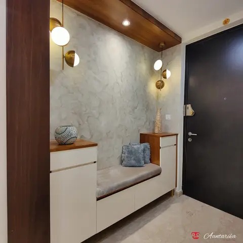 Entrance foyer with a textured plaster feature wall, brass globe sconces, and a cushioned bench flanked by white lacquer shoe cabinets facing the dark main
