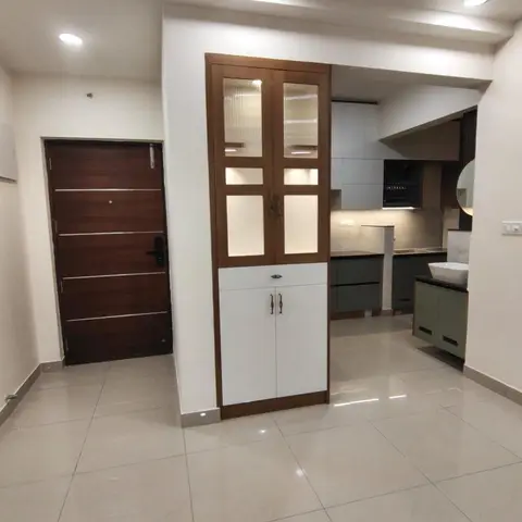 Entrance foyer with a wood-panel main door and an adjoining fluted-glass crockery display cabinet in wood-and-white finish