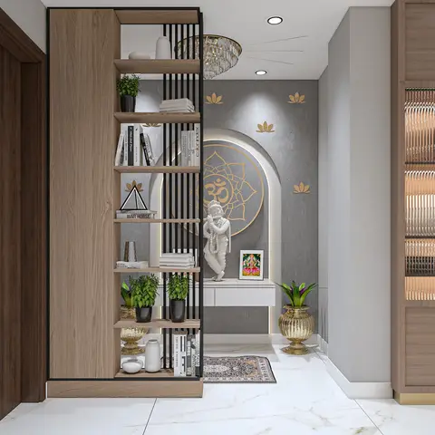 Entrance foyer with an open wood bookshelf room divider beside a backlit arched prayer niche featuring an Om medallion and a statue, under a crystal chandelier.