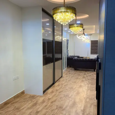 Entrance hallway with a circular false ceiling and tiered crystal chandelier over wood flooring