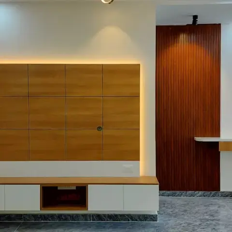 Entrance passage with a backlit wood-panel feature wall over a floating console, a wood-slat clad column and a patterned wood-and-glass main door beyond