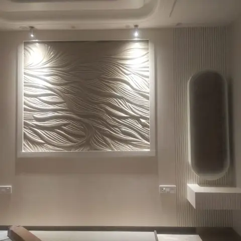 Entrance wall with a large sculptural 3D wave-textured panel spotlit above, and a floating console with an oval mirror in a fluted-panel niche beside it