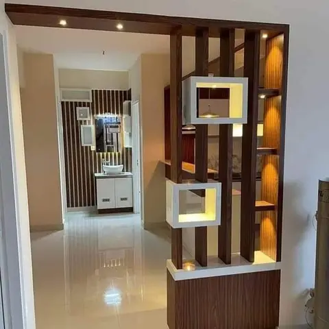 Entrance zone with a slatted wood partition unit holding two backlit box display niches, opening into a hallway with a striped-wall vanity console beyond