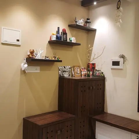 Entry corner with a dark-veneer shoe cabinet and bench, square-perforated shutters