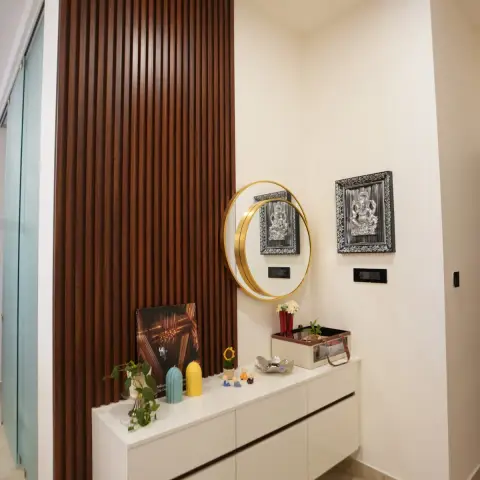 Entry corner with a white floating shoe drawer unit set against a full-height walnut fluted panel