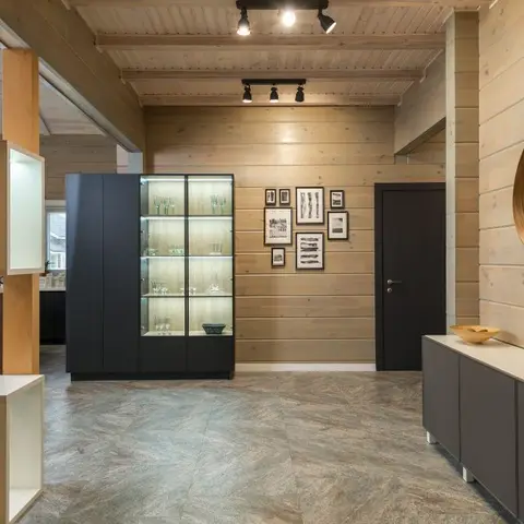 Entry hall with full-height horizontal wood cladding, a backlit glass-front display cabinet for glassware, a gallery wall of framed prints