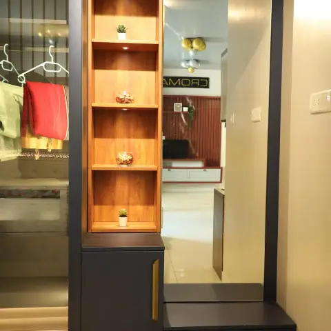 Entryway wardrobe and dresser unit in charcoal finish with brass handles, a backlit wood display niche for plants and trinkets