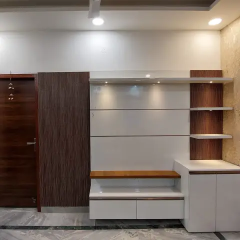 Entryway with a dark wood main door hung with a toran beside a fluted-panel closet