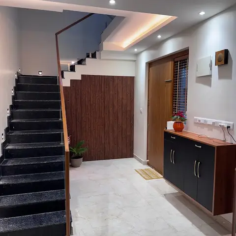 Entryway with a wood main door, a wall-mounted walnut-and-black console cabinet, a vertical wood-slat feature wall