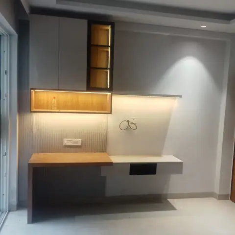 Floating study desk with overhead grey laminate cabinetry, an open wood-lined display niche, and a fluted panel backsplash with under-shelf LED lighting.