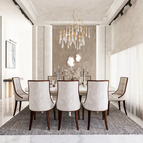 Formal dining room where a gold branch chandelier hung with glass teardrops drops over a marble-top table