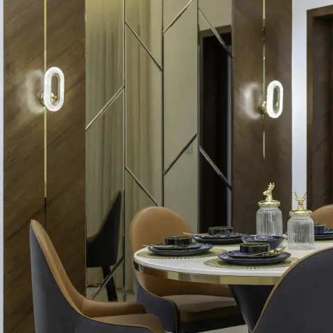 Four-seat dining corner set against a walnut-veneer wall split by thin brass inlay lines