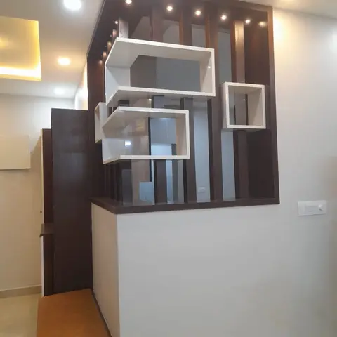 Foyer partition wall with vertical wood fluted slats and cantilevered white display cubes, dividing the entrance from the living area