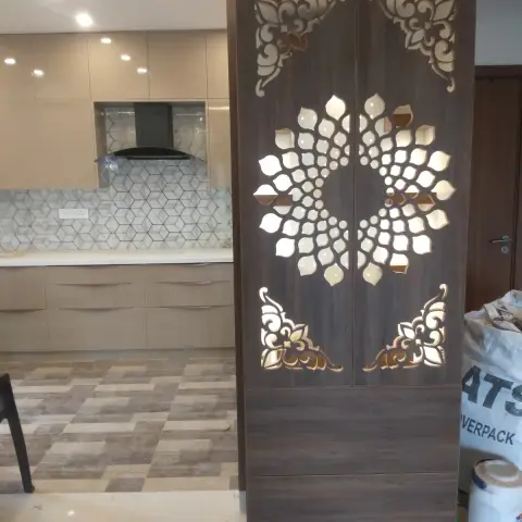Free-standing pooja mandir cabinet with a temple-style pediment top and backlit lotus-pattern laser-cut wood doors