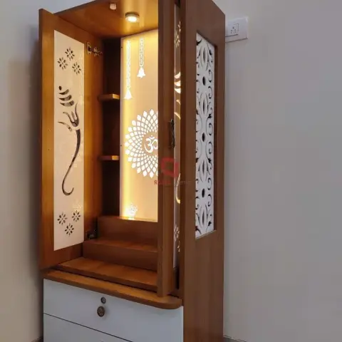 Freestanding teak-finish mandir with a backlit Om sunburst rear panel, CNC-cut Ganesha and floral jaali doors, and a stepped platform over two white drawers