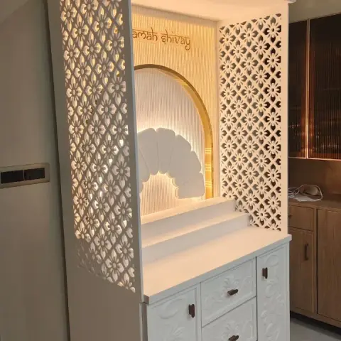 Freestanding white mandir with CNC floral-jaali side and back screens, a backlit fluted arch carrying 'namah shivay' lettering