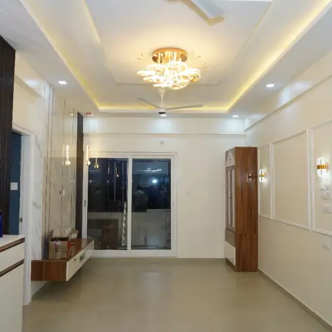Freshly finished, still-unfurnished hall photographed at night: a rose-gold mirror lattice wall over a white counter on the left