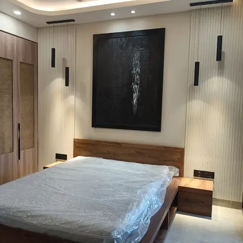 Freshly handed-over bedroom with the mattress still in its plastic wrap, a cane-panelled walnut wardrobe on one wall