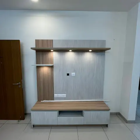 Freshly installed, unfurnished TV feature wall in a light wood and grey-woodgrain finish with three spotlights and a floating two-tone console