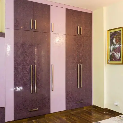 Full-height bedroom wardrobe in mottled aubergine and lilac gloss laminate with long steel bar handles
