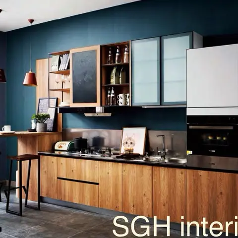 Galley kitchen with a deep teal accent wall, natural wood-grain shutters, open display shelving and a raised breakfast counter with two industrial bar stools