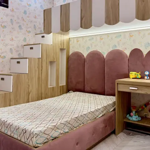 Girl's room with a dusty-rose velvet bed under arched upholstered headboard panels, a bird-print wallpaper
