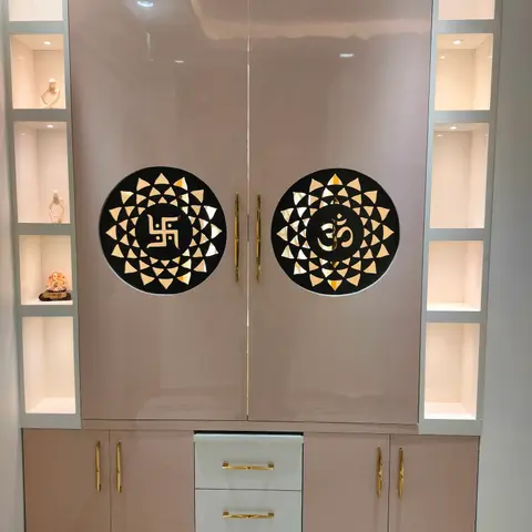 Glossy mauve pooja unit with mirrored Om and swastik cutout medallions, gold handles, flanked by backlit display niches holding small idols.
