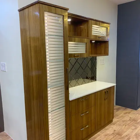 Glossy teak crockery unit with fluted-glass shutters, a mirrored diamond-pattern backsplash, and a quartz counter with integrated shelf lighting.