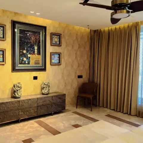 Gold-mottled textured bedroom wall hung with one dark framed centre artwork flanked by four small square prints