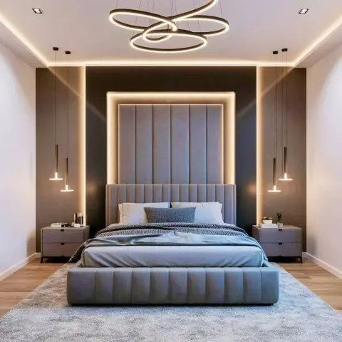 Grey channel-tufted headboard rising almost to the ceiling inside a backlit recess on a dark taupe accent wall
