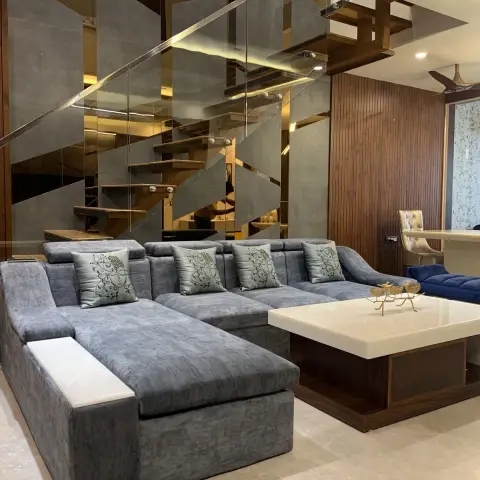Grey chenille U-shaped sofa with printed satin cushions facing an onyx-top coffee table on a wenge base
