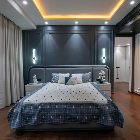 Grey king bedroom with a dark moulded panel headboard wall, warm cove-lit stepped ceiling, sheer patterned curtains and a couple figurine on the nightstand