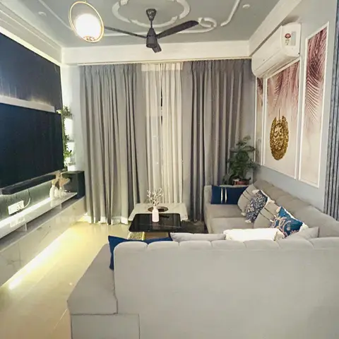 Grey L-shaped sectional sofa living room with a fluted panel TV wall and cove-lit ceiling, navy accent cushions.