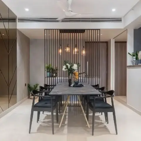 Grey marble-top dining table on a brass X-frame with black metal-and-cane armchairs