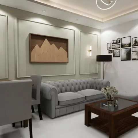 Grey tufted chesterfield sofa below a framed wooden mountain-relief panel flanked by two slim rectangular sconces