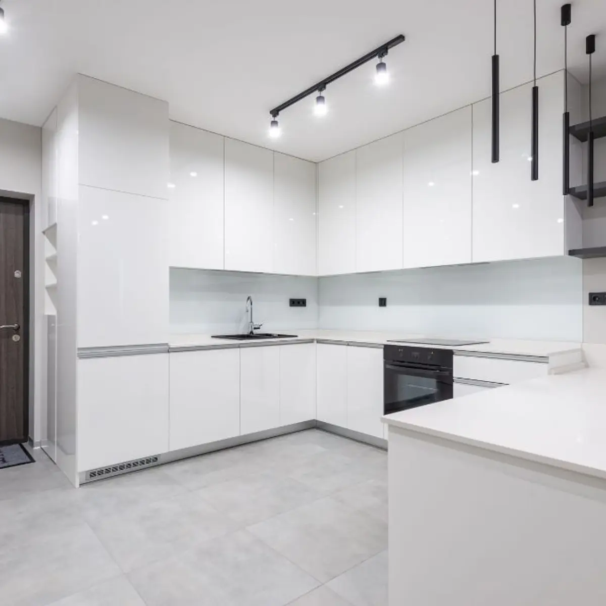All-white handleless L-shaped kitchen with a peninsula counter