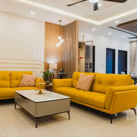 Living room with mustard-yellow sofas, moulded accent wall and fluted wood partition