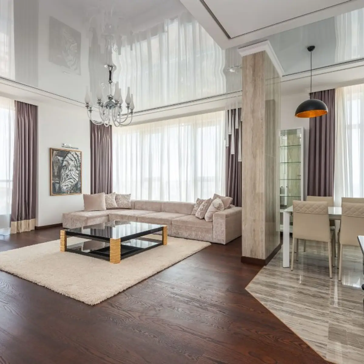 Double-height open-plan living space with a glossy stretch ceiling overhead