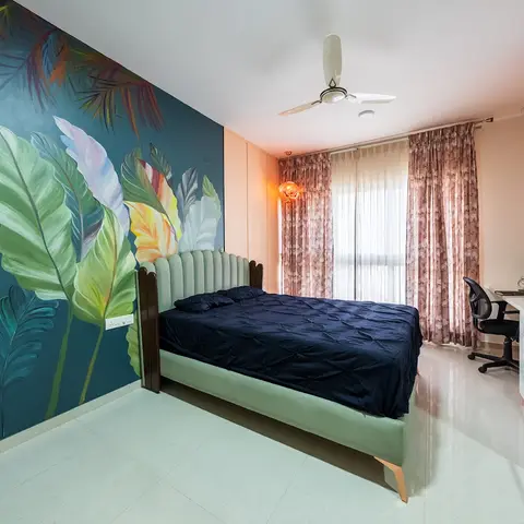 Hand-painted teal mural of oversized tropical leaves across the bedhead wall, with a mint fluted-headboard bed under navy bedding and a corner study desk by